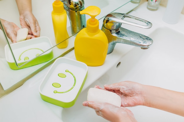 Little girl washing her hands with soap