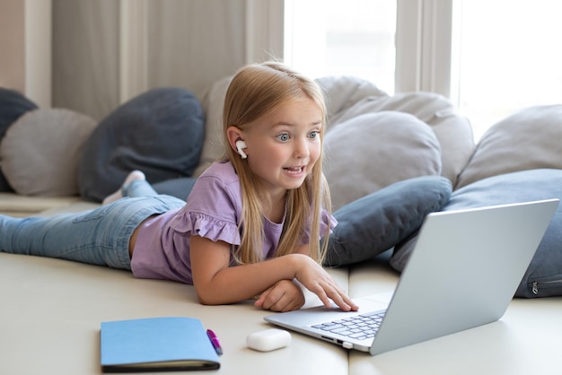 Photo little girl watch online videos with headphones. online lesson for a student,lesson with a tutor