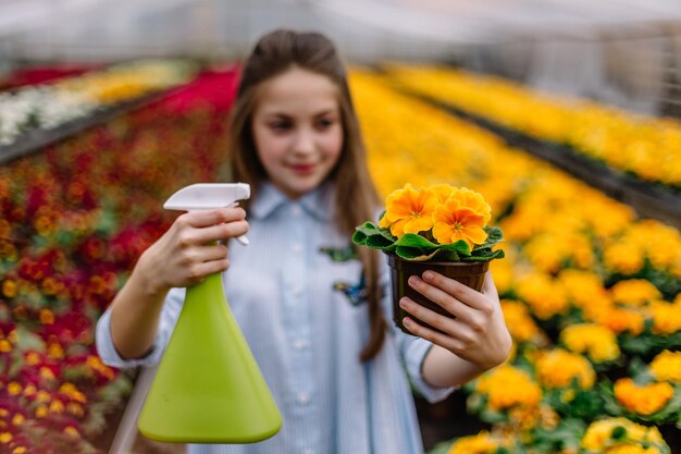 Bambina che innaffia i fiori in un giardino