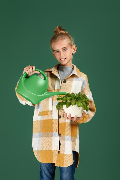 Little girl watering plants in a flower pot