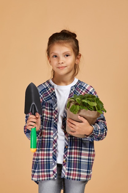 Little girl watering plants in a flower pot