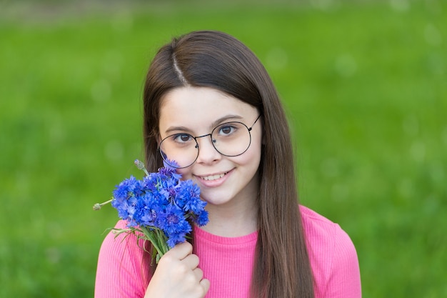 Little girl wear vintage rim eyeglasses green lawn background, summer vacation concept.