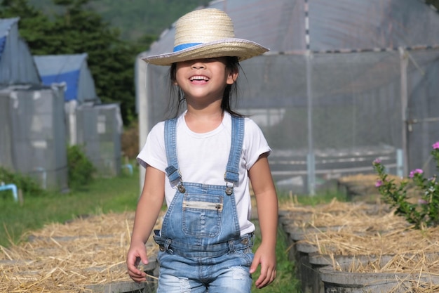 写真 帽子をかぶった小さな女の子は,庭で母親を助け,小さな庭師は,野菜の庭で遊んでいる可愛い女の子.