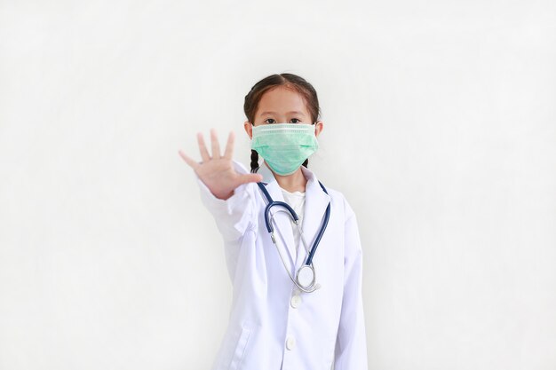 Little girl wearing a doctor's uniform and medical mask