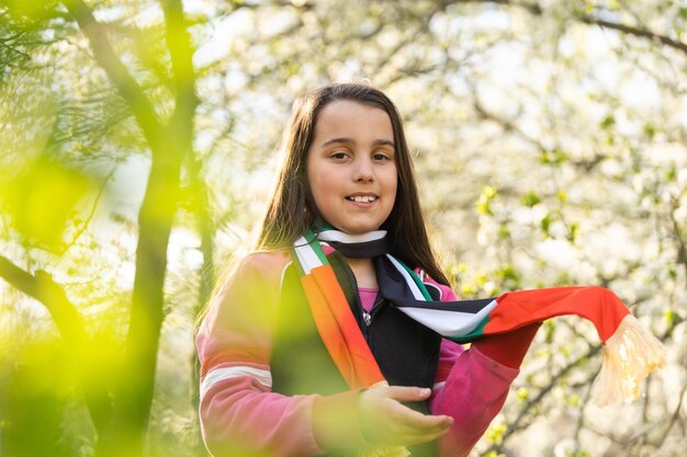 A little girl wearing an emirates flag ribbon