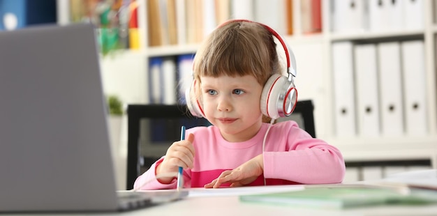 ヘッドセットをかぶった女の子楽しい楽またはオンライン教育