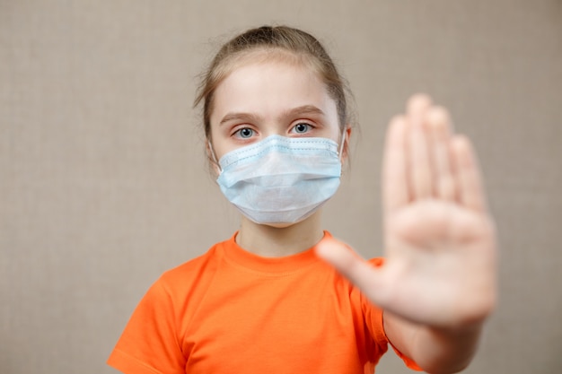 Little Girl Wearing Mask For Protect. Showing Stop Sign. Stop The Virus And Epidemic Diseases. Coronavirus Covid-19.Stay At Home Stay Safe Concept. Selective Focus.