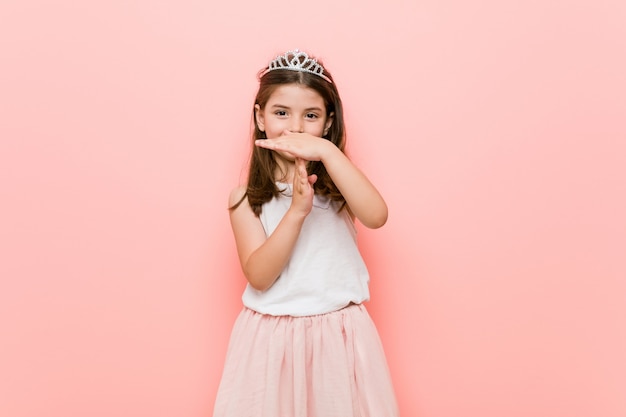 Little girl wearing a princess look showing a timeout gesture.