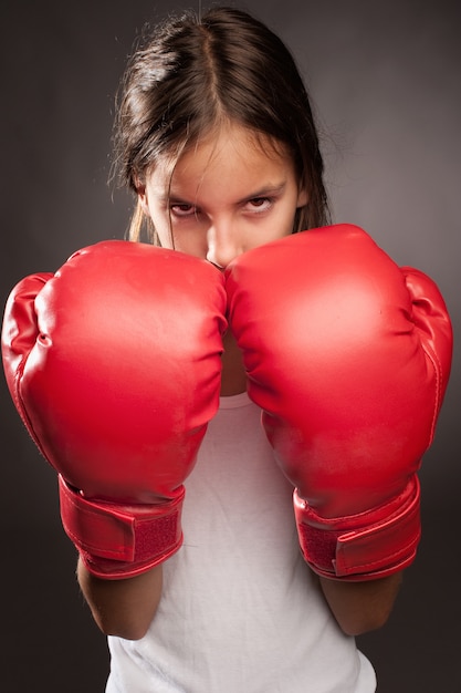 little girl wearing red boxing gloves