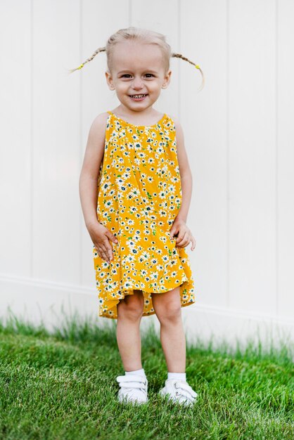 Photo a little girl wearing a yellow sunflower dress