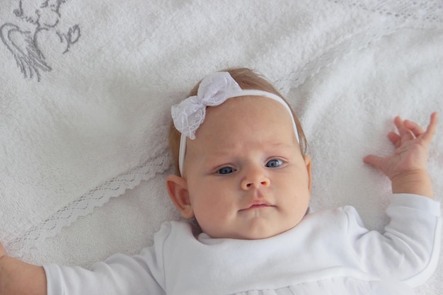 Photo a little girl in white clothes and a cross baptism of a child