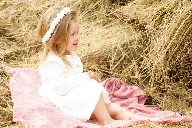 Little girl in a white dress in the manger