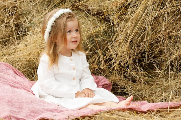 Little girl in a white dress in the manger