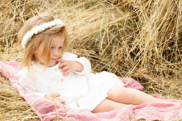 Little girl in a white dress in the manger