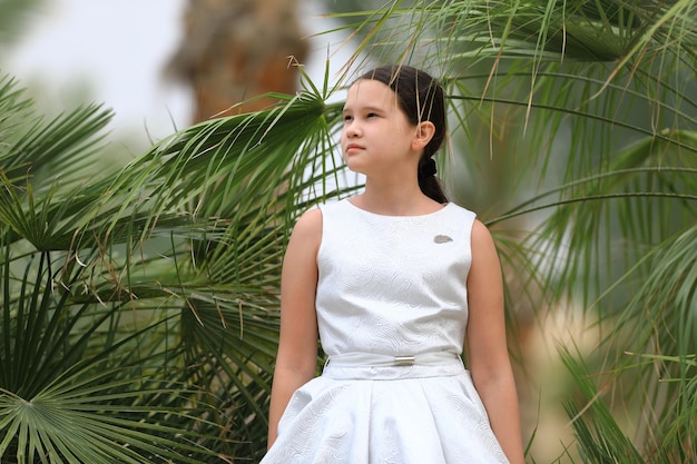 Little girl in a white dress on the tropics