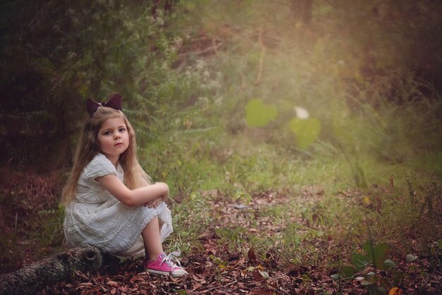 Photo little girl in white dress in woods