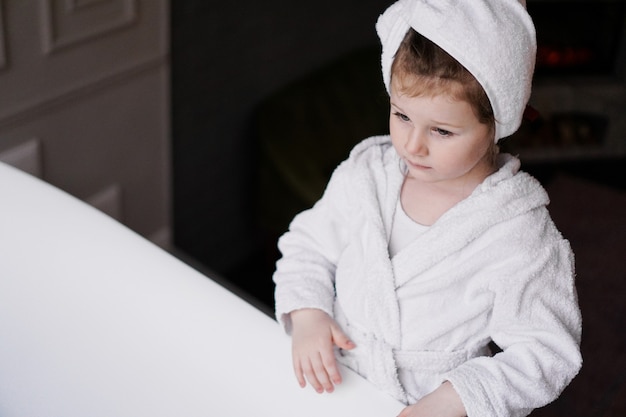 Photo little girl in a white robe after taking a bath