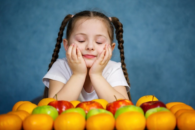 Little girl in white T-shirt love fruit