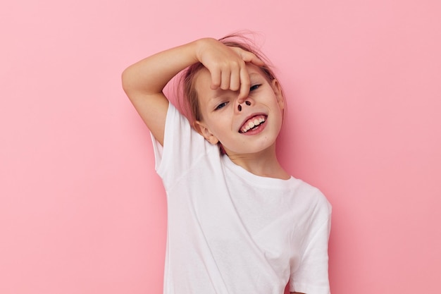 Little girl in a white tshirt smile pink background