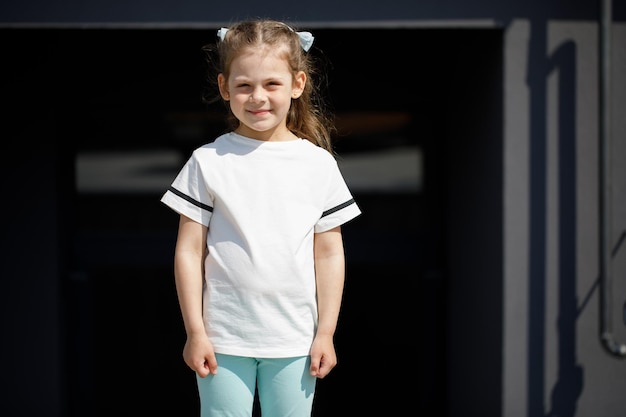 로고 또는 인쇄용 디자인 모형을 위한 흰색 티셔츠 공간에 있는 어린 소녀