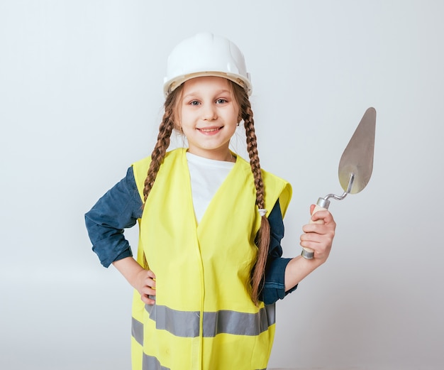 Photo little girl on the white wall. construction