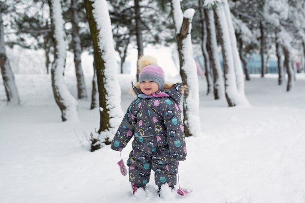 Bambina in inverno in una foresta innevata.