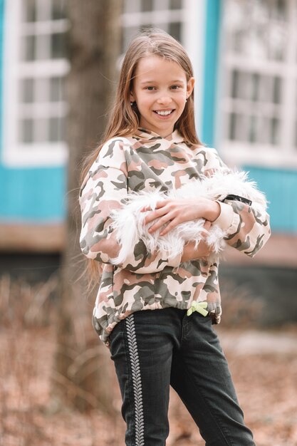 写真 白い子犬を持つ少女。女の子の手の中に子犬