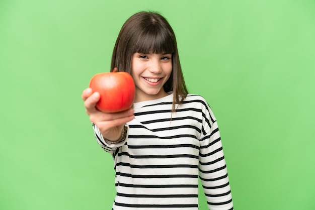 幸せそうな表情で孤立したクロマ キーの背景の上にリンゴを持つ少女