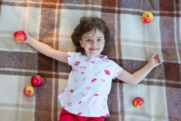 The little girl with apples in the orchard The view from above