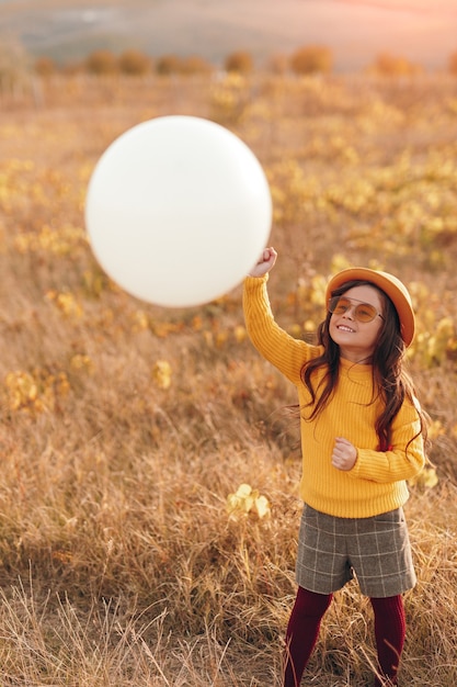 Little girl with balloon in the field