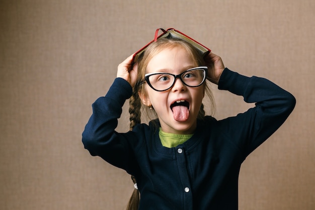 Foto bambina con un libro sopra la testa