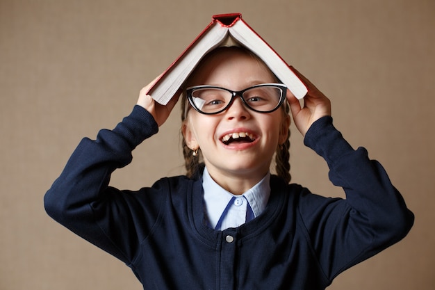 Bambina con un libro sopra la sua testa