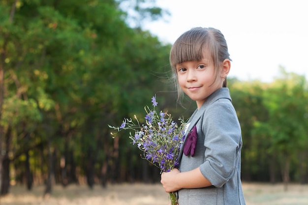 公園で野花の花束を持つ少女