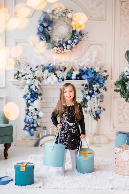 Little girl with boxes of Christmas gifts. A child in a New Year's decor