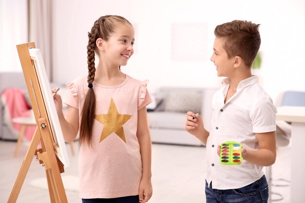 Little girl with brother painting at home