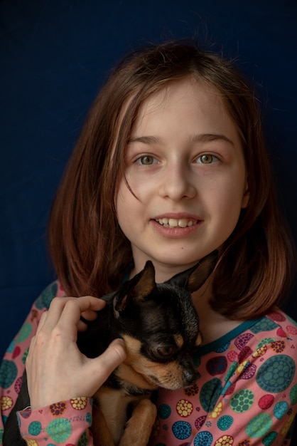 Little girl with a chihuahua. Girl holding chihuahua. Girl with her pet in her arms.