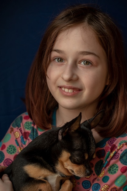 Little girl with a chihuahua. Girl holding chihuahua. Girl with her pet in her arms.