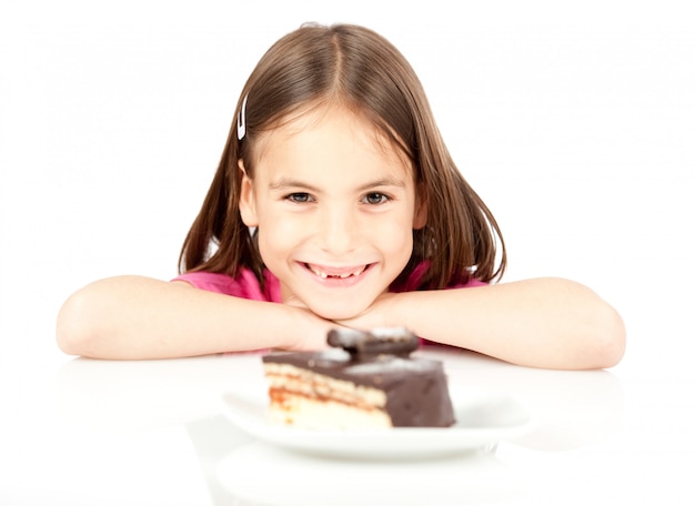 白で隔離されるチョコレートケーキを持つ少女