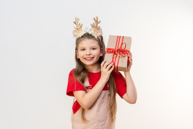 A little girl with a Christmas gift on a white isolated background.