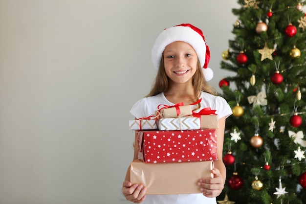 Little girl with christmas gifts in christmas interior