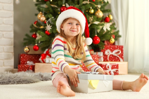 Little girl with christmas gifts in christmas interior