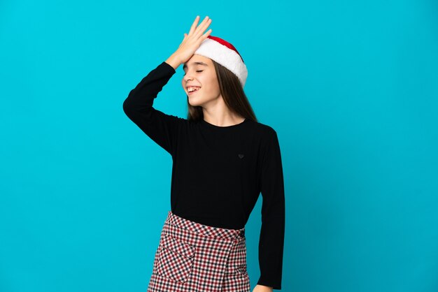 Little girl with Christmas hat isolated on blue background has realized something and intending the solution