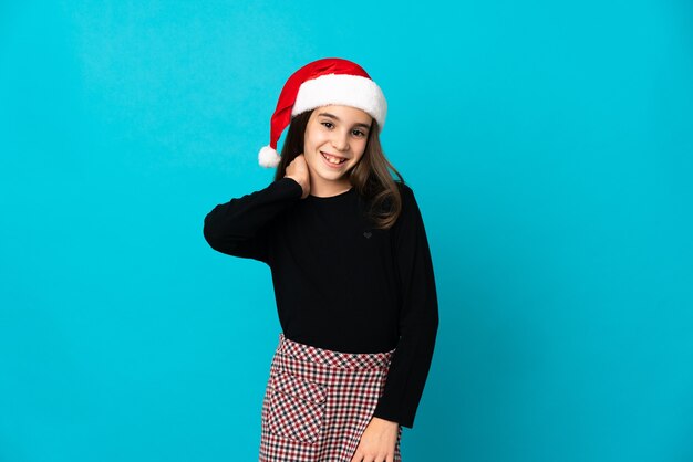 Little girl with Christmas hat isolated on blue background laughing