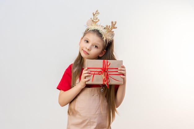 A little girl with Christmas horns on her head is holding in her hands .