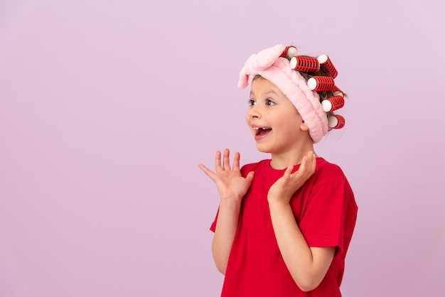 Una bambina con i bigodini in testa è felice.