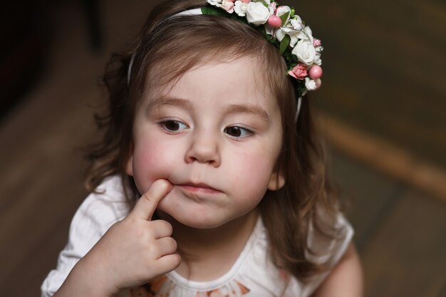 Little girl with curly hair, having fun while posing at the camera