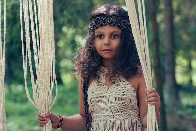 Bambina con capelli ricci scuri vestita da indigena