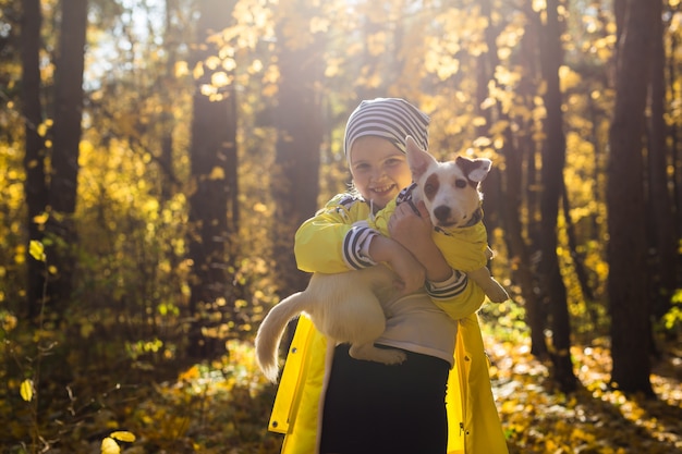 Little girl with a dog jack russell terrier in the autumn park