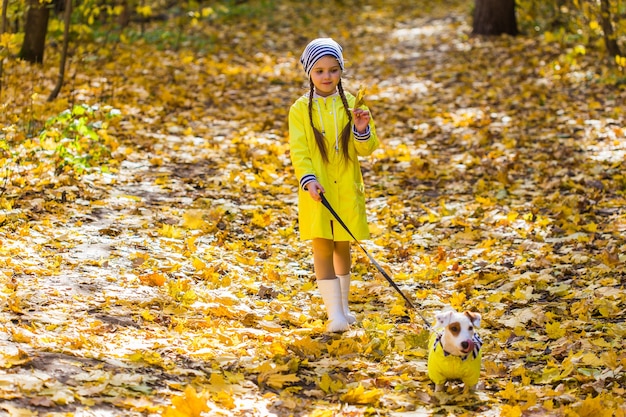 Bambina con un cane jack russell terrier. concetto di bambino, infanzia, amicizia e animale domestico. piccolo cane