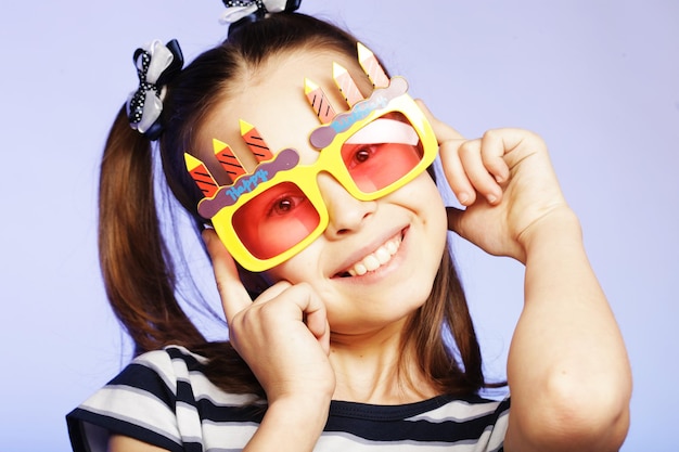 Little girl with fun orange carnaval glasses